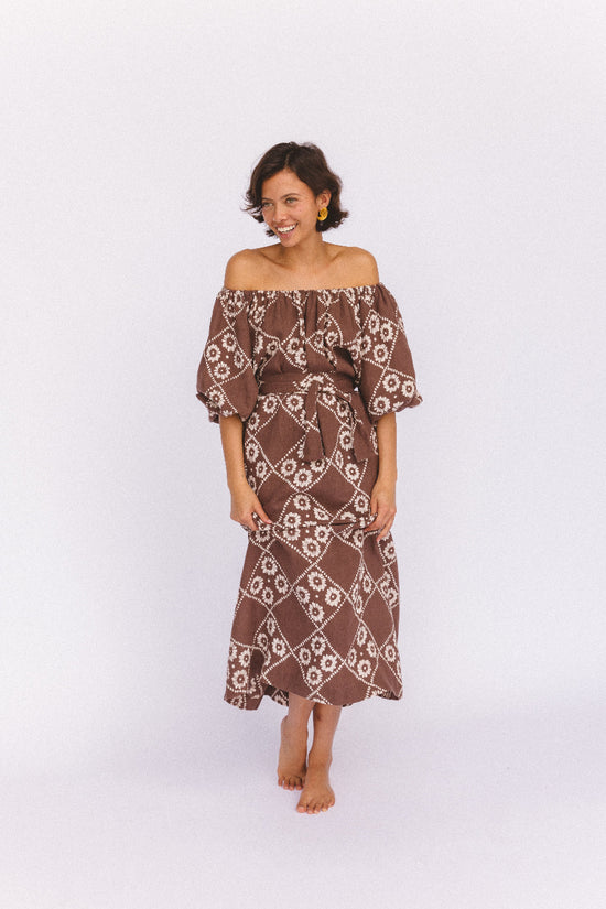 Dahlia Maxi Dress Maple — studio shot off-shoulder smiling, 3/4 view showing billowy sleeves and block print linen skirt, ethical slow fashion from Jaipur | Daughters of India