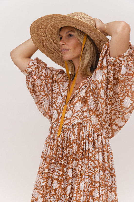 Daughters of India Kyra Midi Dress in Caramel — studio close-up with straw hat, V-neckline and billowed sleeves